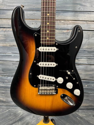 Electric guitar with a sunburst finish on a wooden background