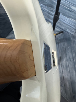 Close-up of a wooden handle on a white surface with a blurred background