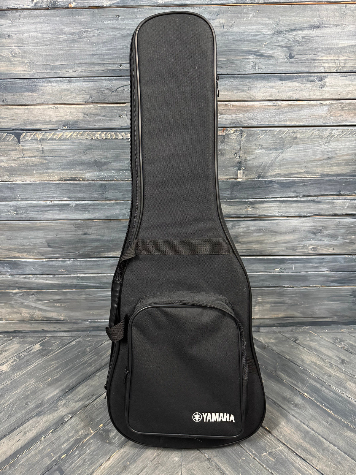 Black Yamaha guitar case on a wooden floor