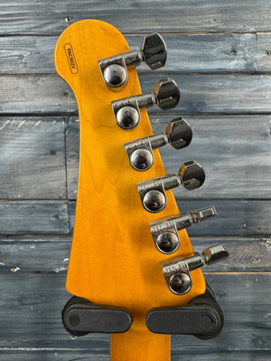 Guitar headstock with tuning pegs on a wooden background