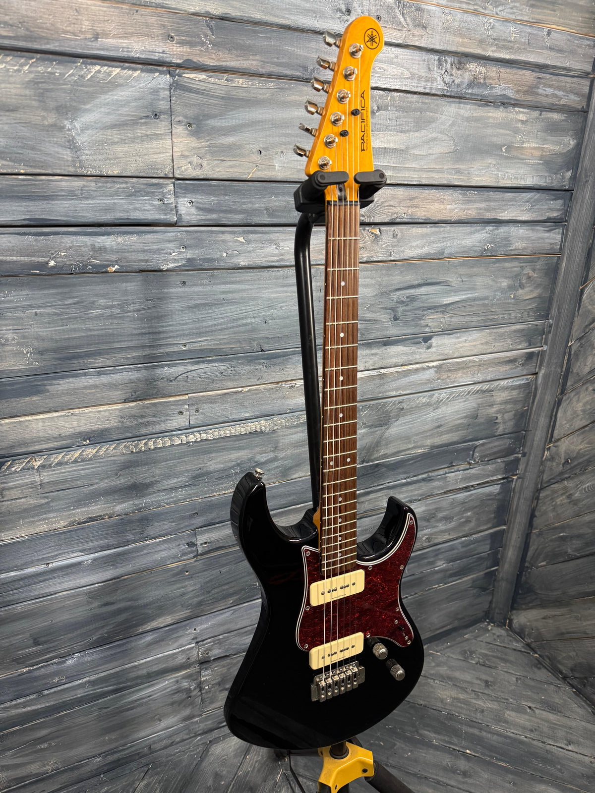Electric guitar with a black and orange design on a wooden floor