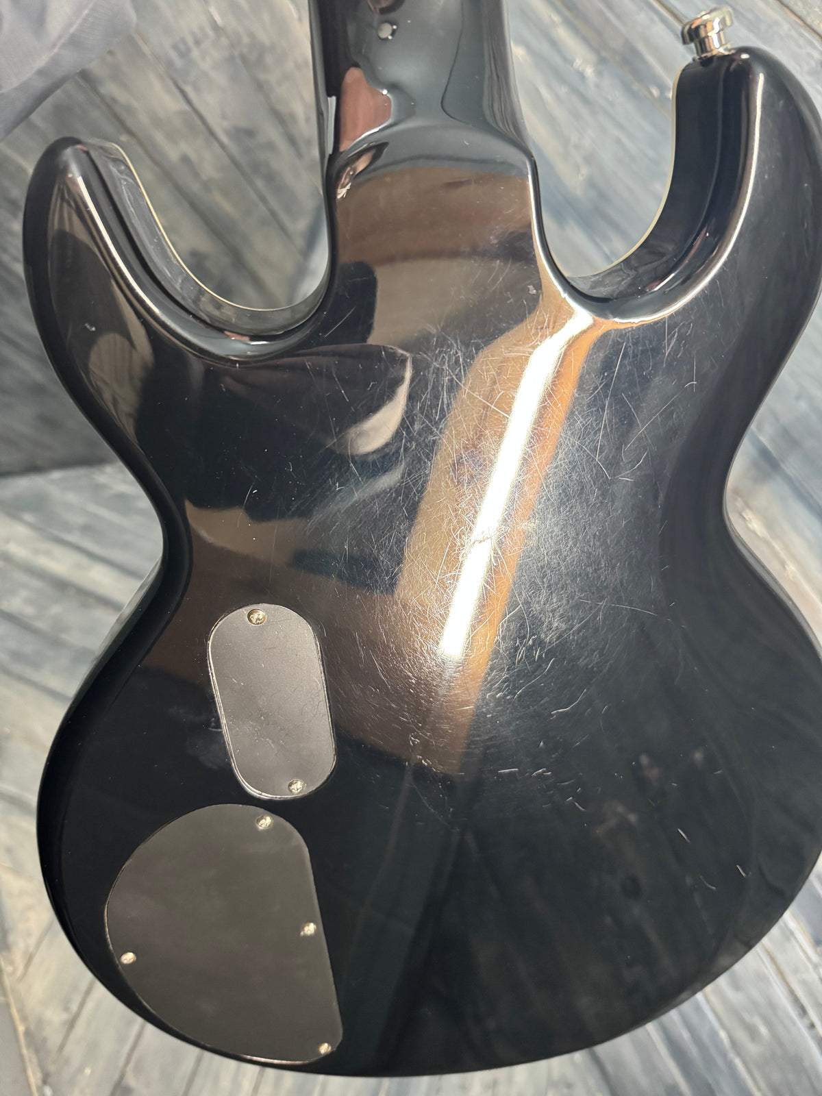Black electric guitar body on a reflective surface