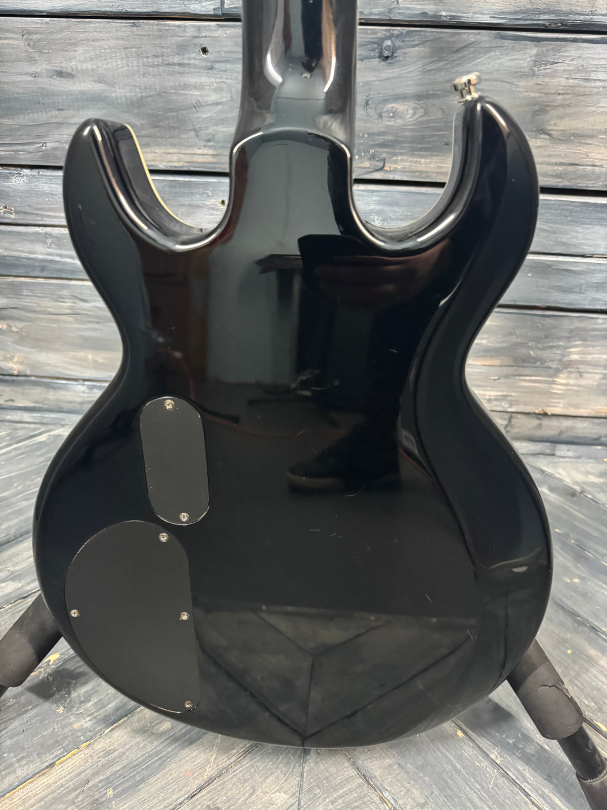 Black electric guitar on a wooden floor