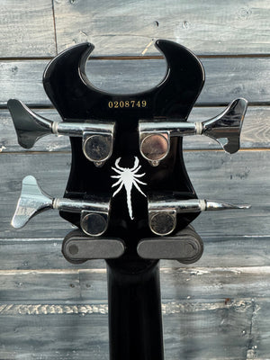 Guitar headstock with spider logo on a wooden background