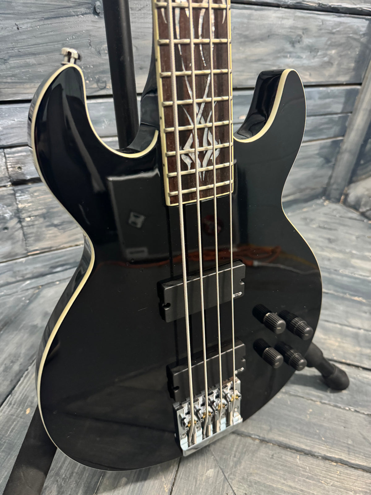 Black electric bass guitar on a wooden surface