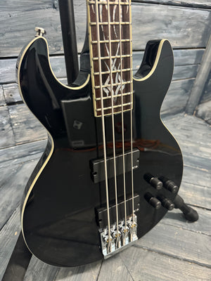 Black electric bass guitar on a wooden surface