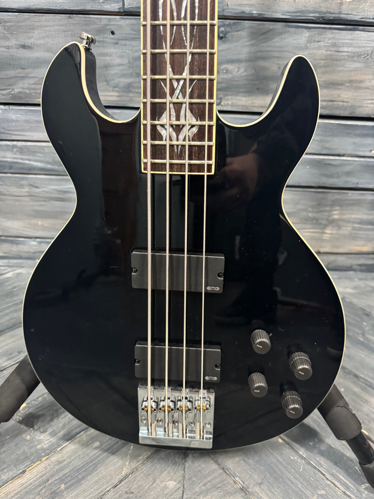 Black electric bass guitar on a wooden surface