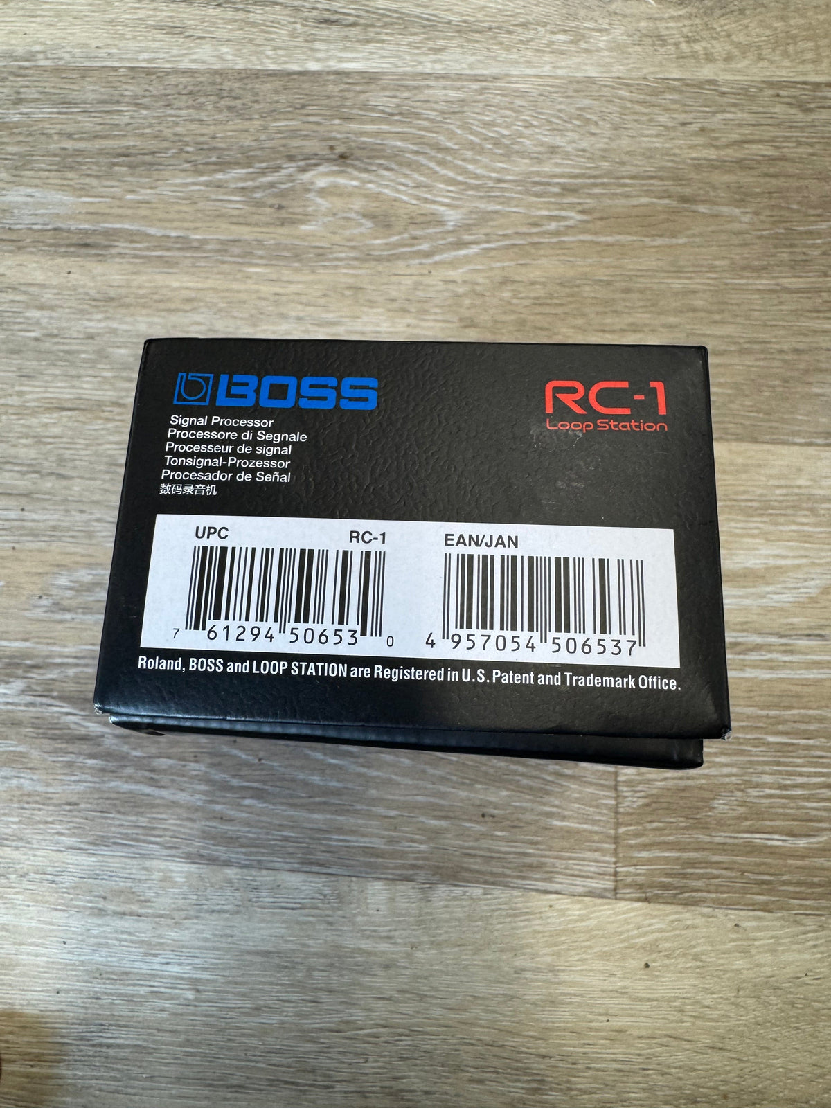 Black battery pack with 'BOSS' branding on a wooden surface