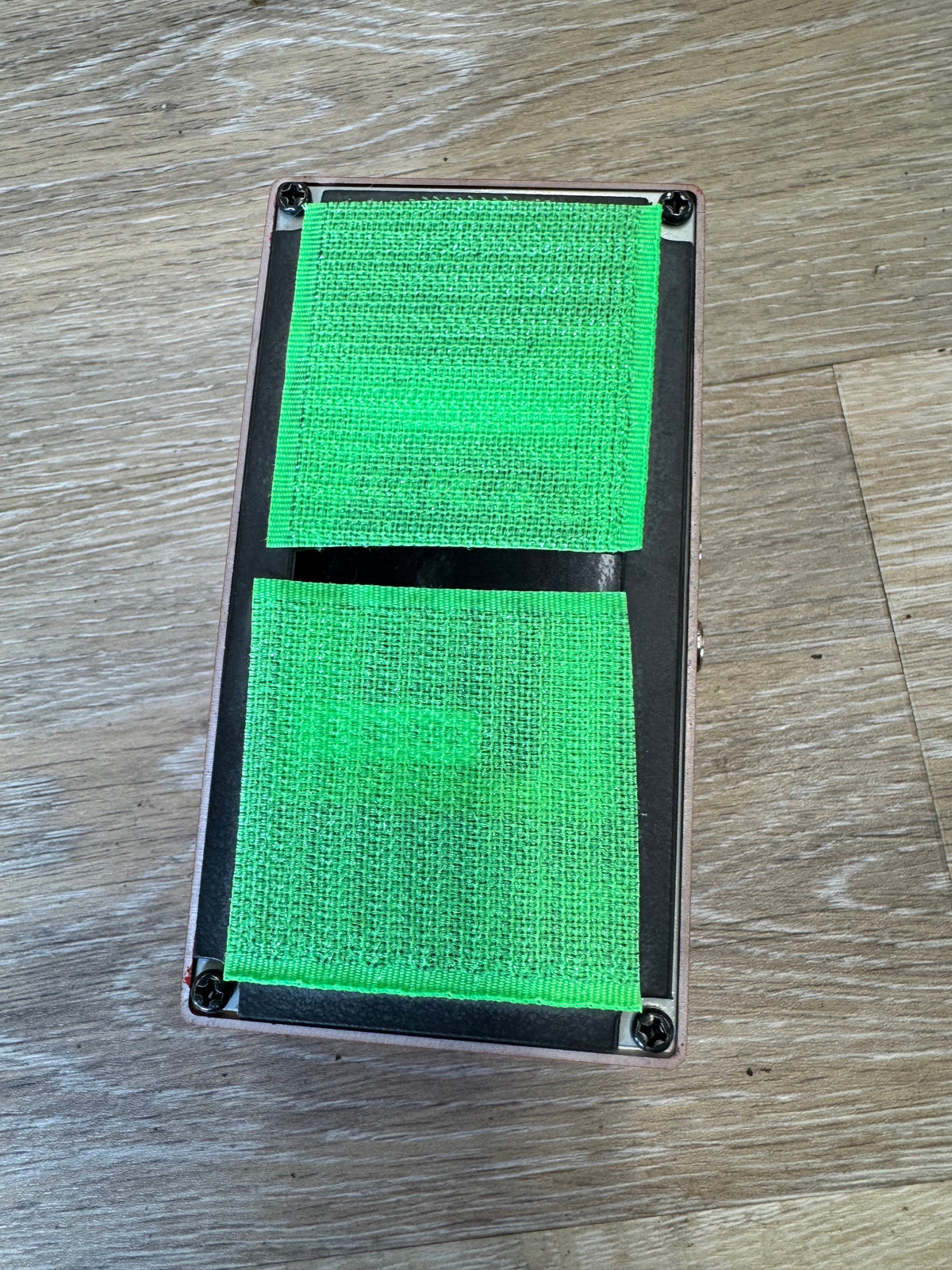 Rectangular frame with two green textured panels on a wooden surface