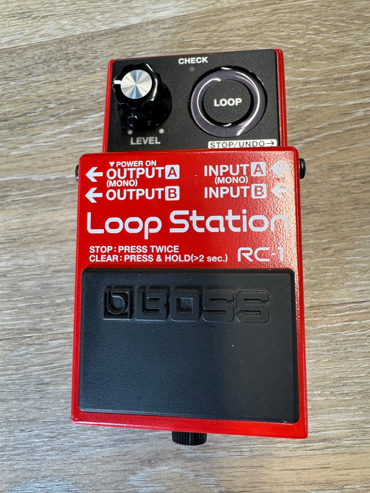 Red and black BOSS Loop Station pedal on a wooden surface