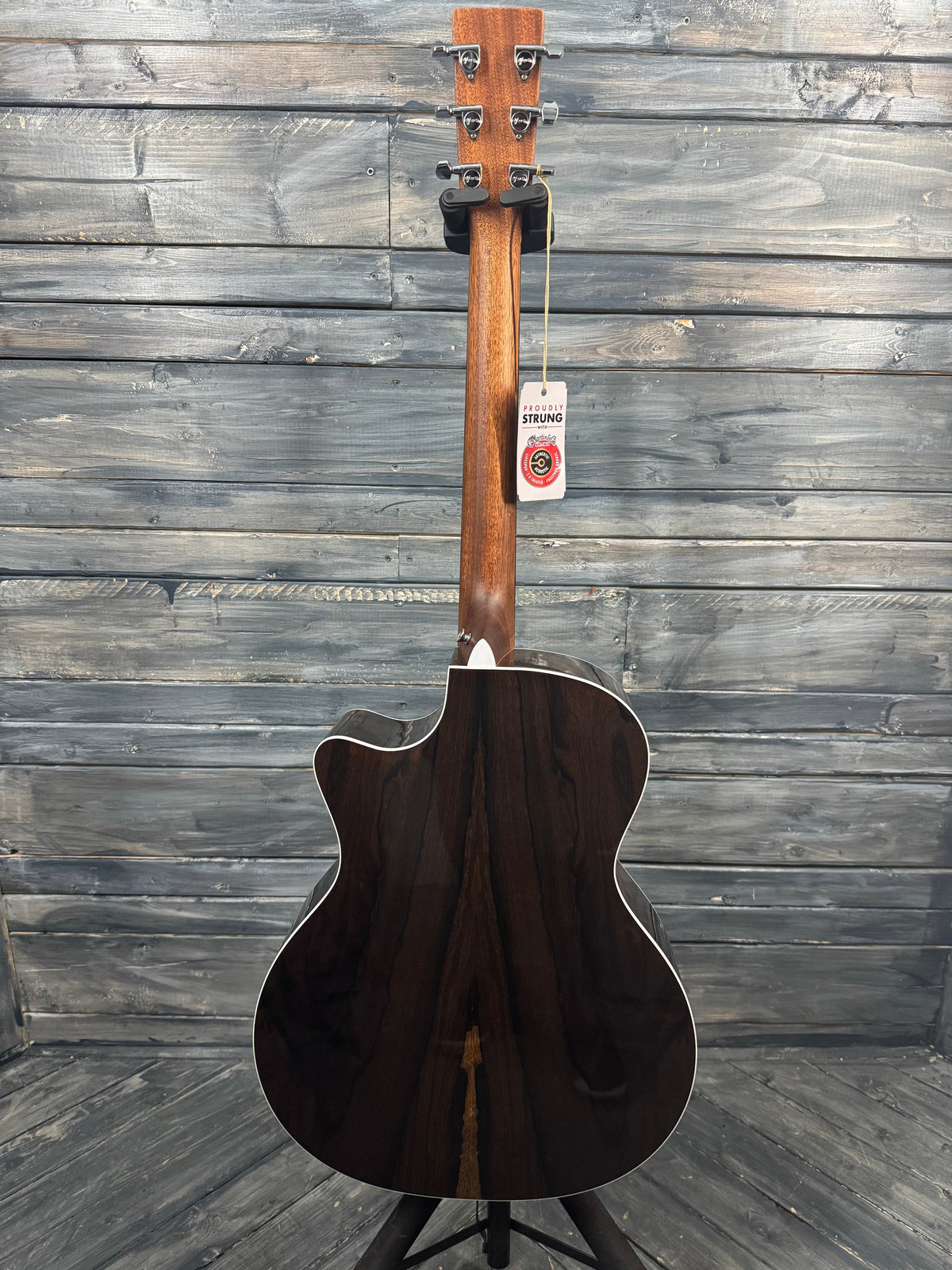 Acoustic guitar leaning against a wooden wall