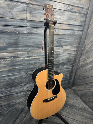 Acoustic guitar leaning against a wooden wall