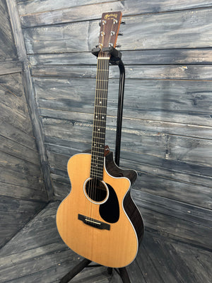 Acoustic guitar leaning against a wooden wall