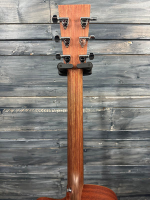 Wooden guitar neck with a strap against a wooden background