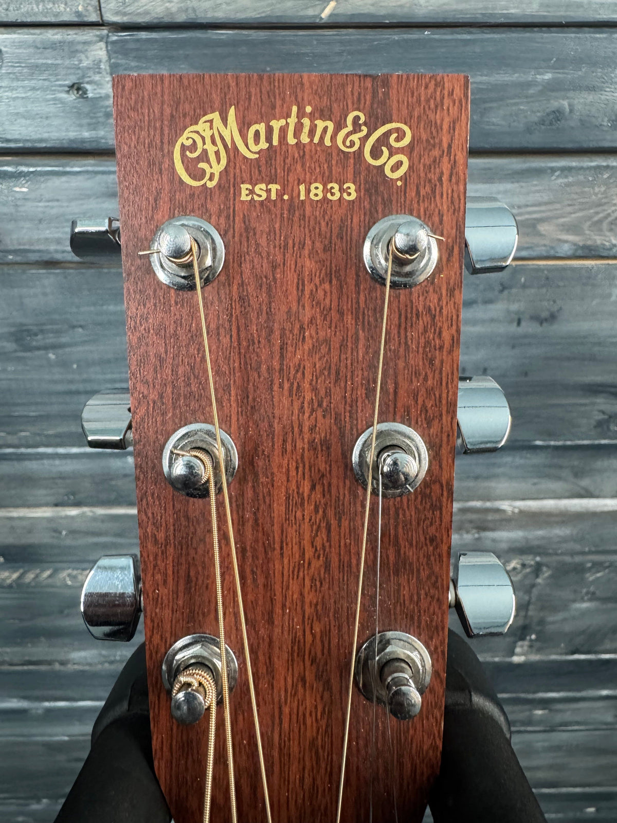 Guitar headstock with 'Martin & Co.' branding on a wooden background