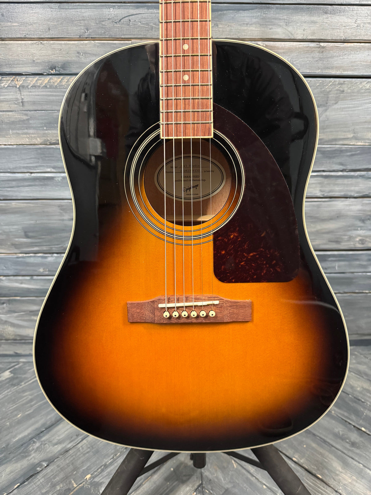Acoustic guitar with a sunburst finish on a wooden surface