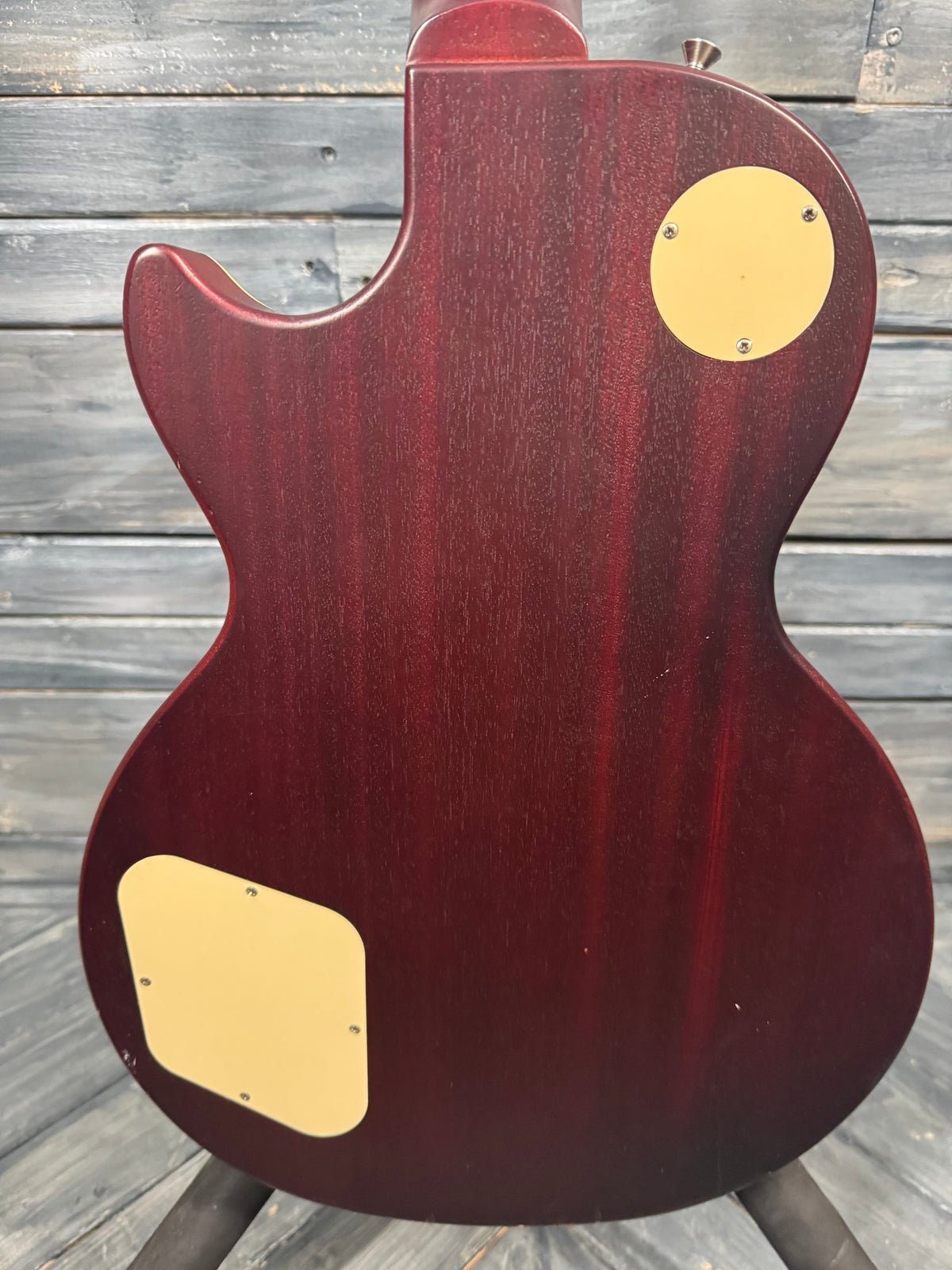 Back view of a red electric guitar on a wooden surface