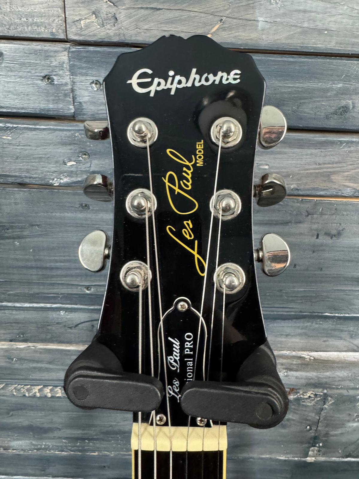 Epiphone Les Paul guitar headstock on a wooden background