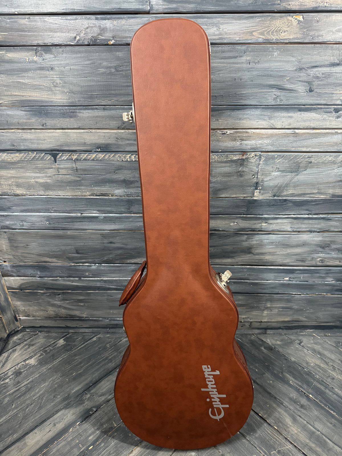 Brown guitar case with 'Epiphone' branding on a wooden surface