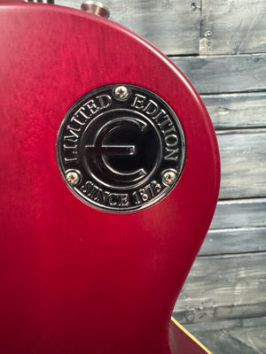 Close-up of a red guitar with a 'Limited Edition' badge on a wooden background