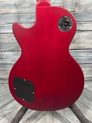 Red electric guitar with a brand logo on a wooden background