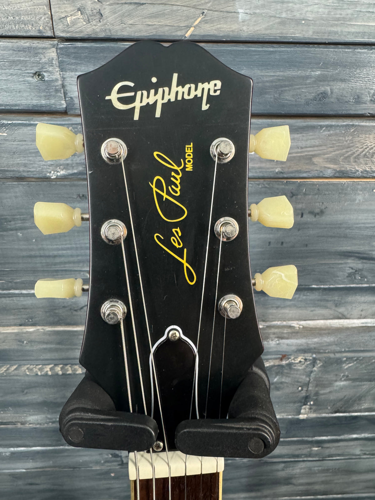 Epiphone Les Paul guitar headstock on a wooden background