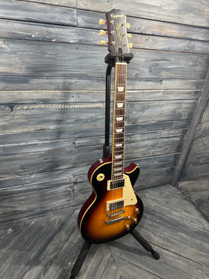 Electric guitar on a stand against a wooden wall