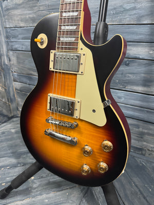 Electric guitar with a sunburst finish against a wooden background