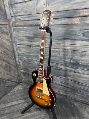Electric guitar on a stand against a wooden wall