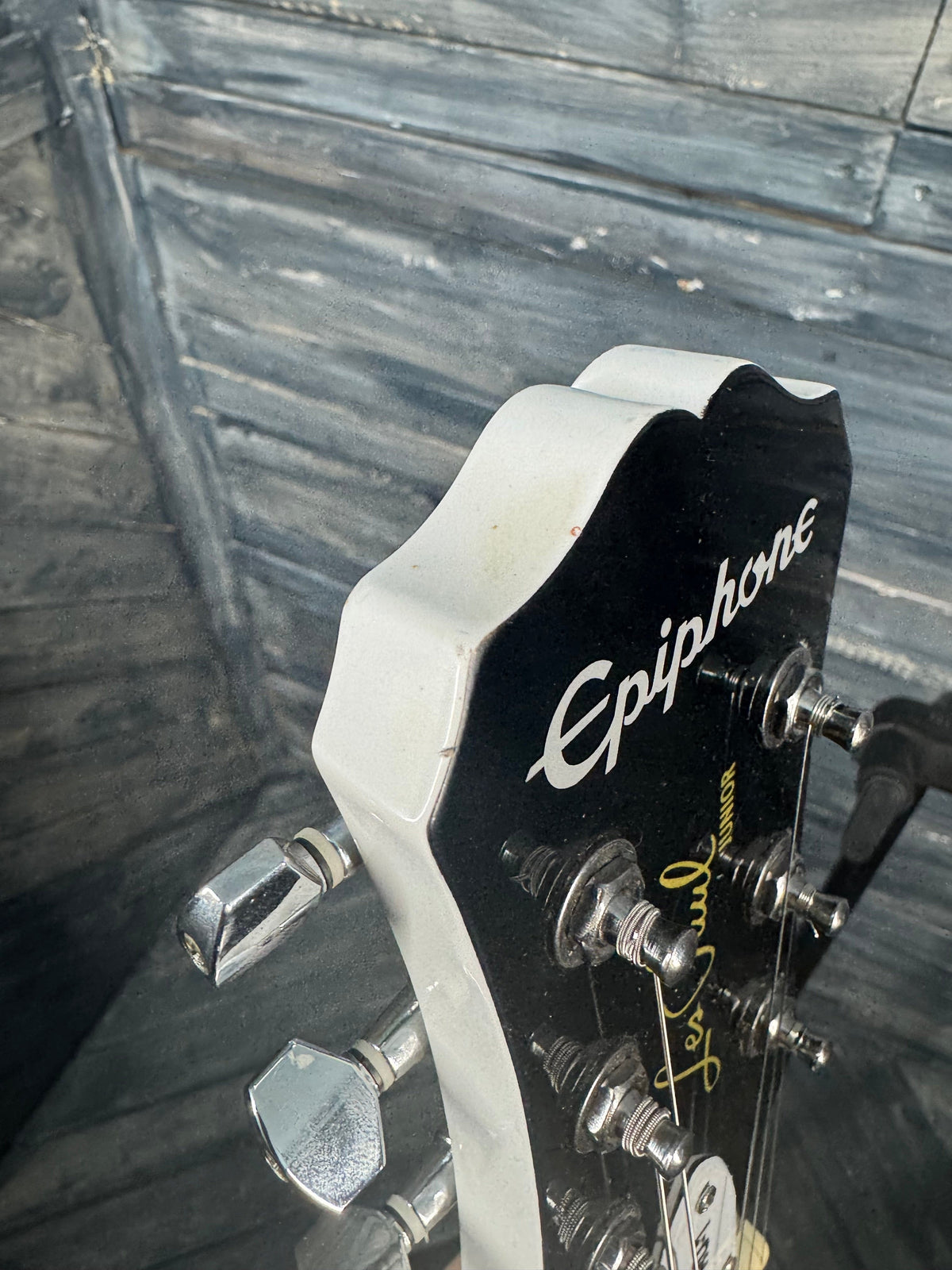 Epiphone guitar headstock on a wooden surface