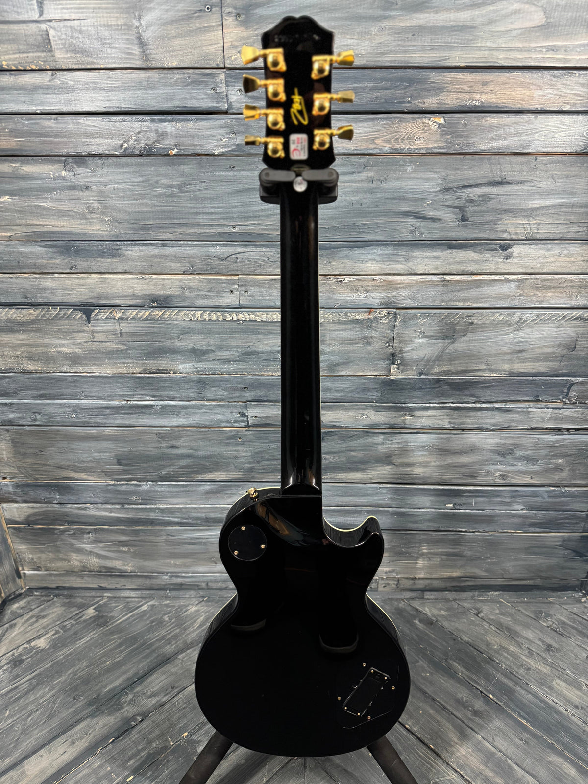 Black electric guitar on a wooden surface