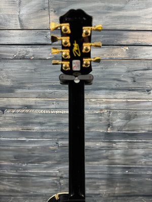 Guitar headstock with six tuning pegs on a wooden background