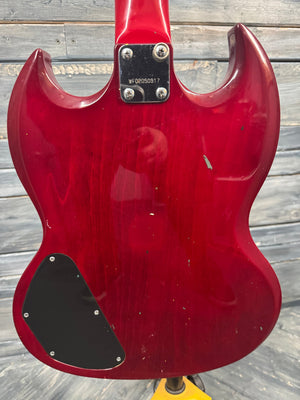 Red electric guitar on a wooden surface