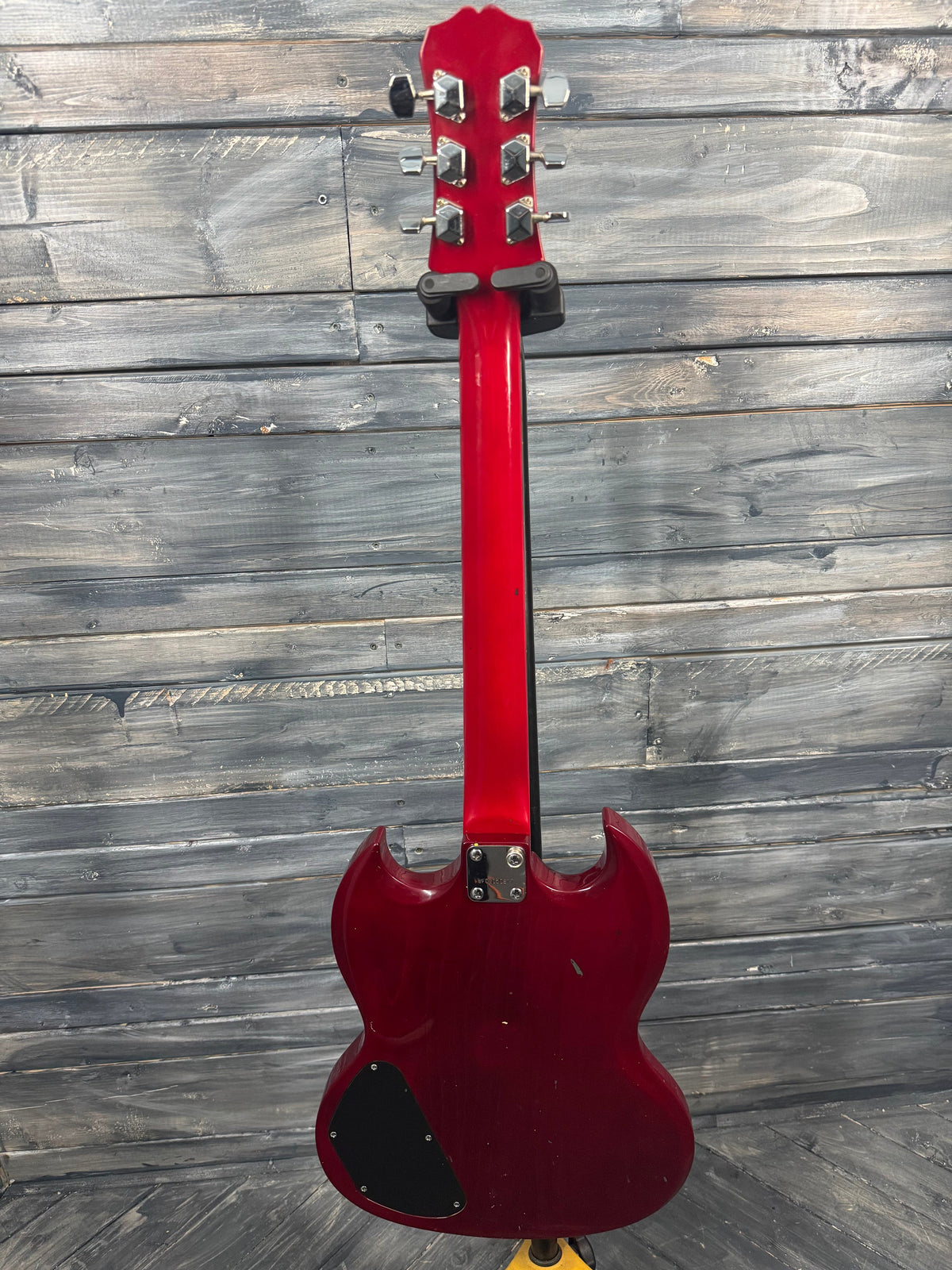 Red electric guitar on a wooden surface