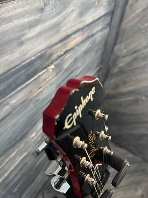 Close-up of a guitar headstock with brand name on a wooden surface