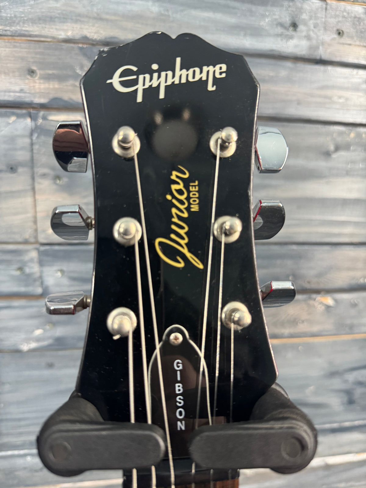Gibson Epiphone guitar headstock with brand names on a wooden background