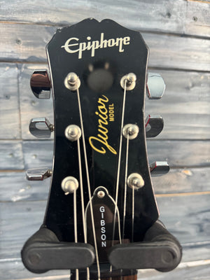 Gibson Epiphone guitar headstock with brand names on a wooden background