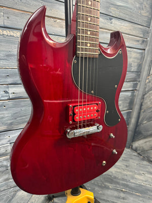 Red electric guitar on a wooden surface