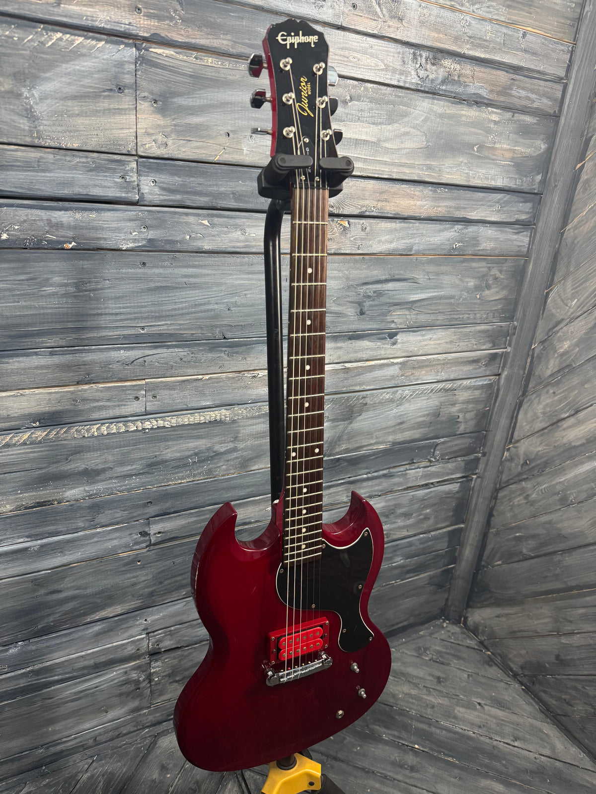 Red electric guitar on a wooden floor