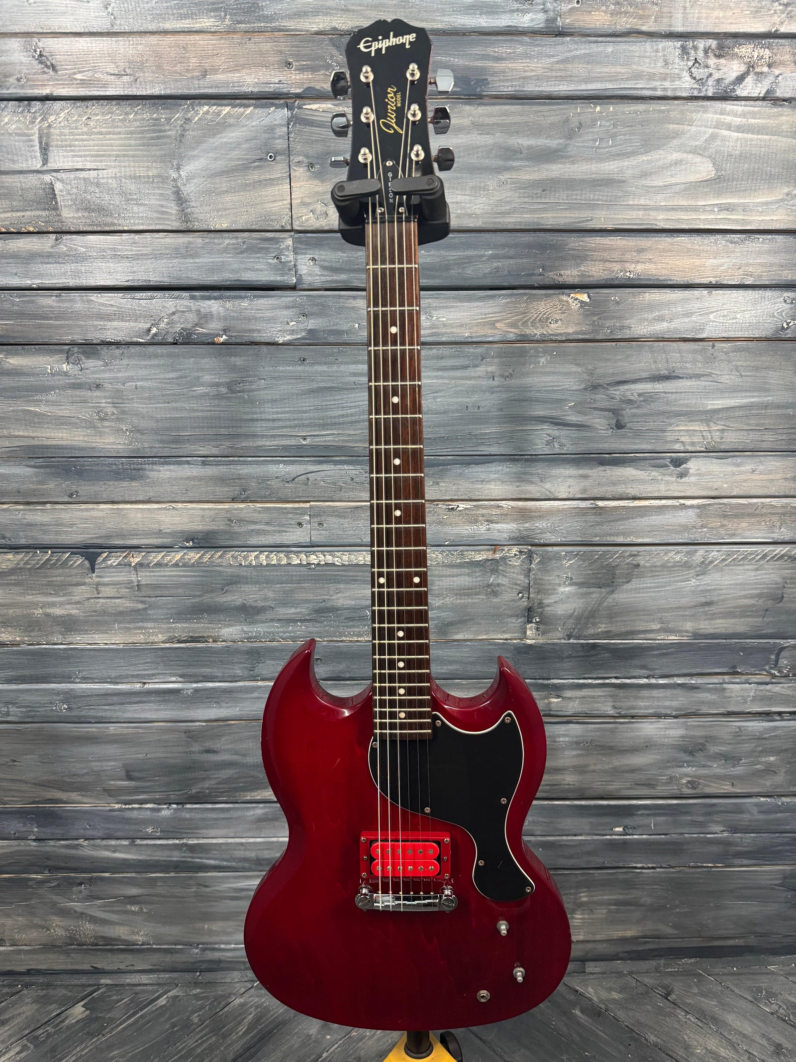 Red electric guitar on a wooden surface