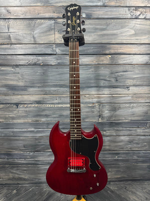 Red electric guitar on a wooden surface