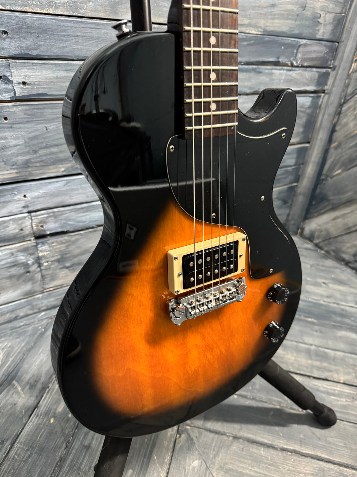 Electric guitar with a sunburst finish on a wooden deck