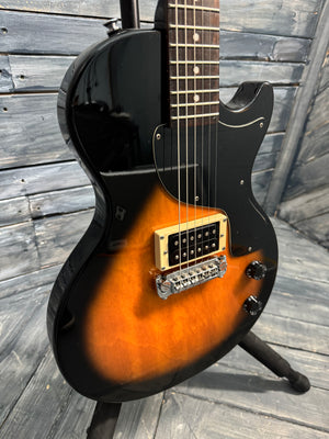 Electric guitar with a sunburst finish on a wooden deck