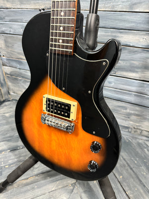 Electric guitar with black and orange body on a wooden background