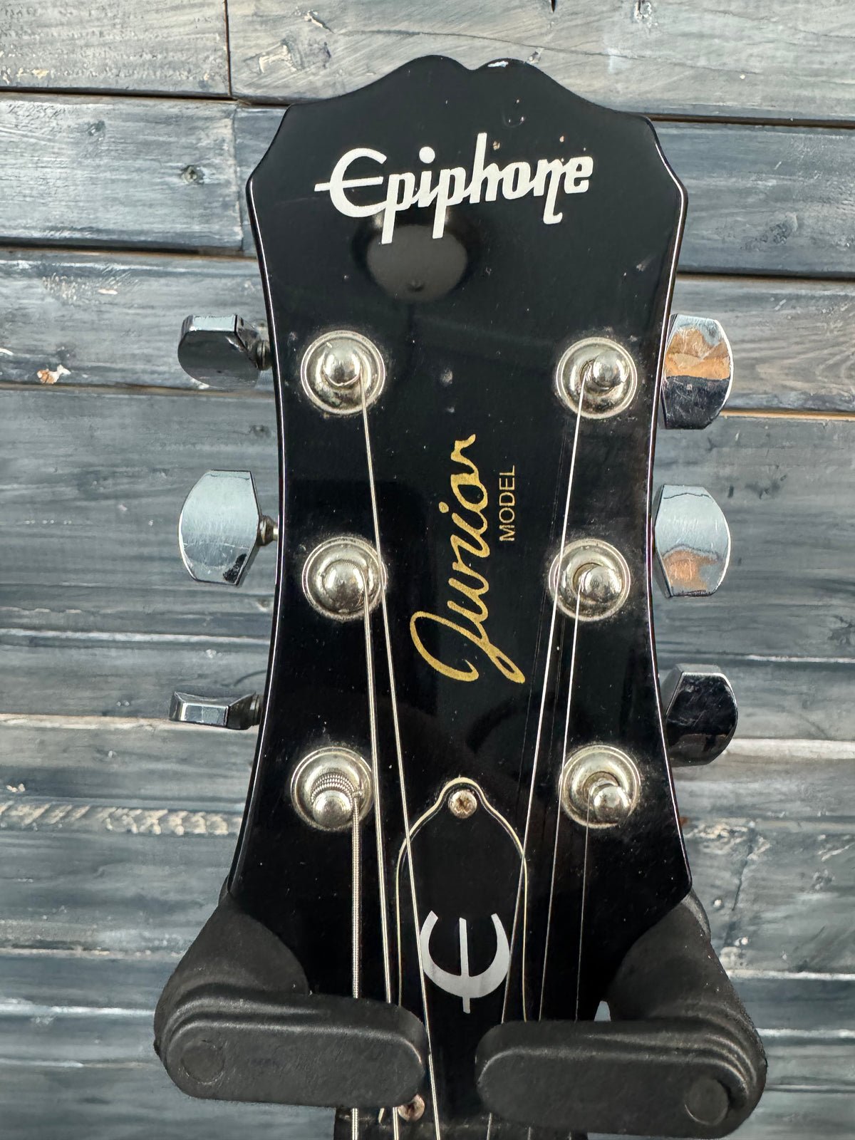 Epiphone guitar headstock with 'Jubilee' model text on a wooden background