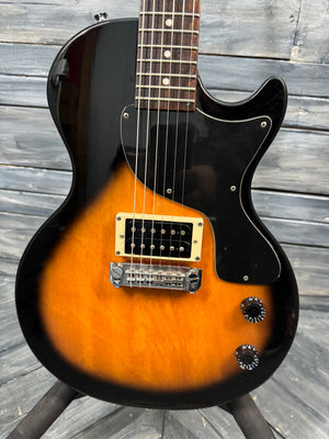 Electric guitar with a sunburst finish on a wooden background