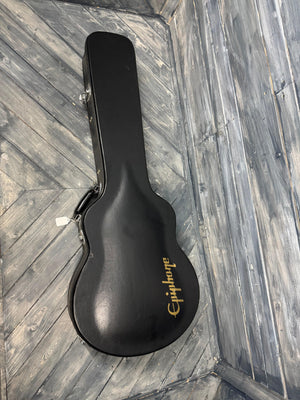 Black guitar case with 'Epiphone' branding on a wooden floor.