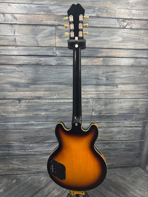 Electric guitar with sunburst finish on a wooden background