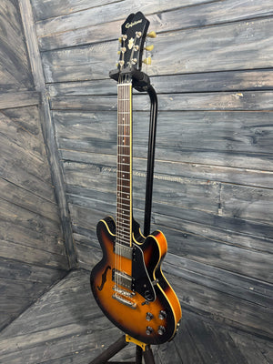 Electric guitar leaning against a wooden wall