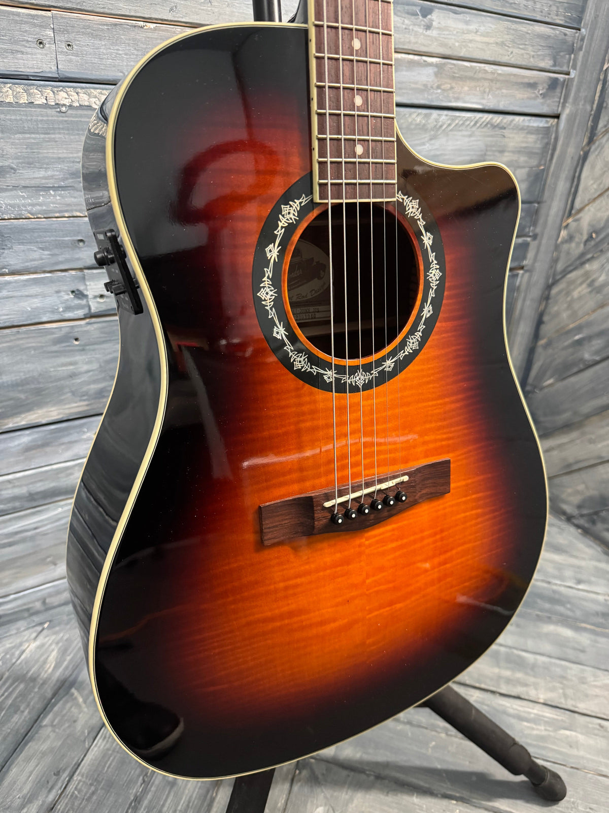 Acoustic guitar with a sunburst finish on a wooden surface